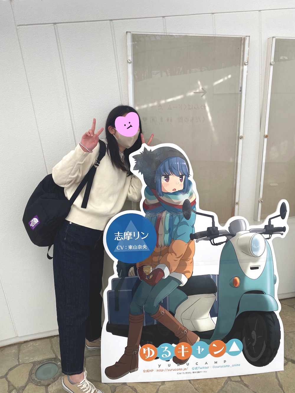 ブルー系のデニムパンツ、ベージュ系のスニーカー、ホワイト系のニット/セーターを着用したレディースの冬コーディネートの2枚目の写真