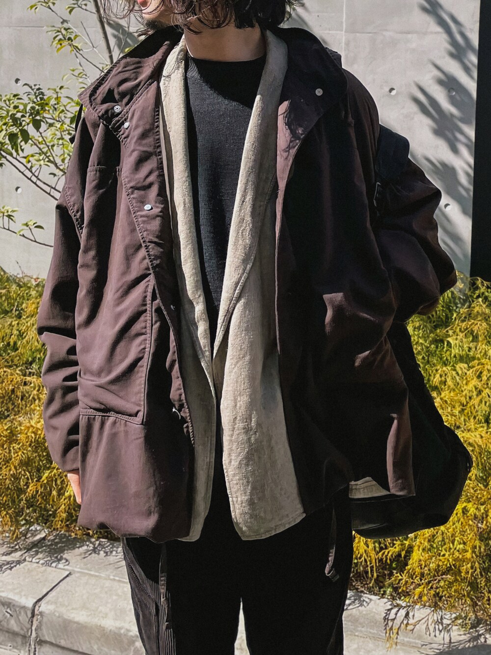 ブラウン系のブルゾン、グレー系のテーラードジャケット、ブラック系のニット/セーターを着用したメンズの冬コーディネートの3枚目の写真