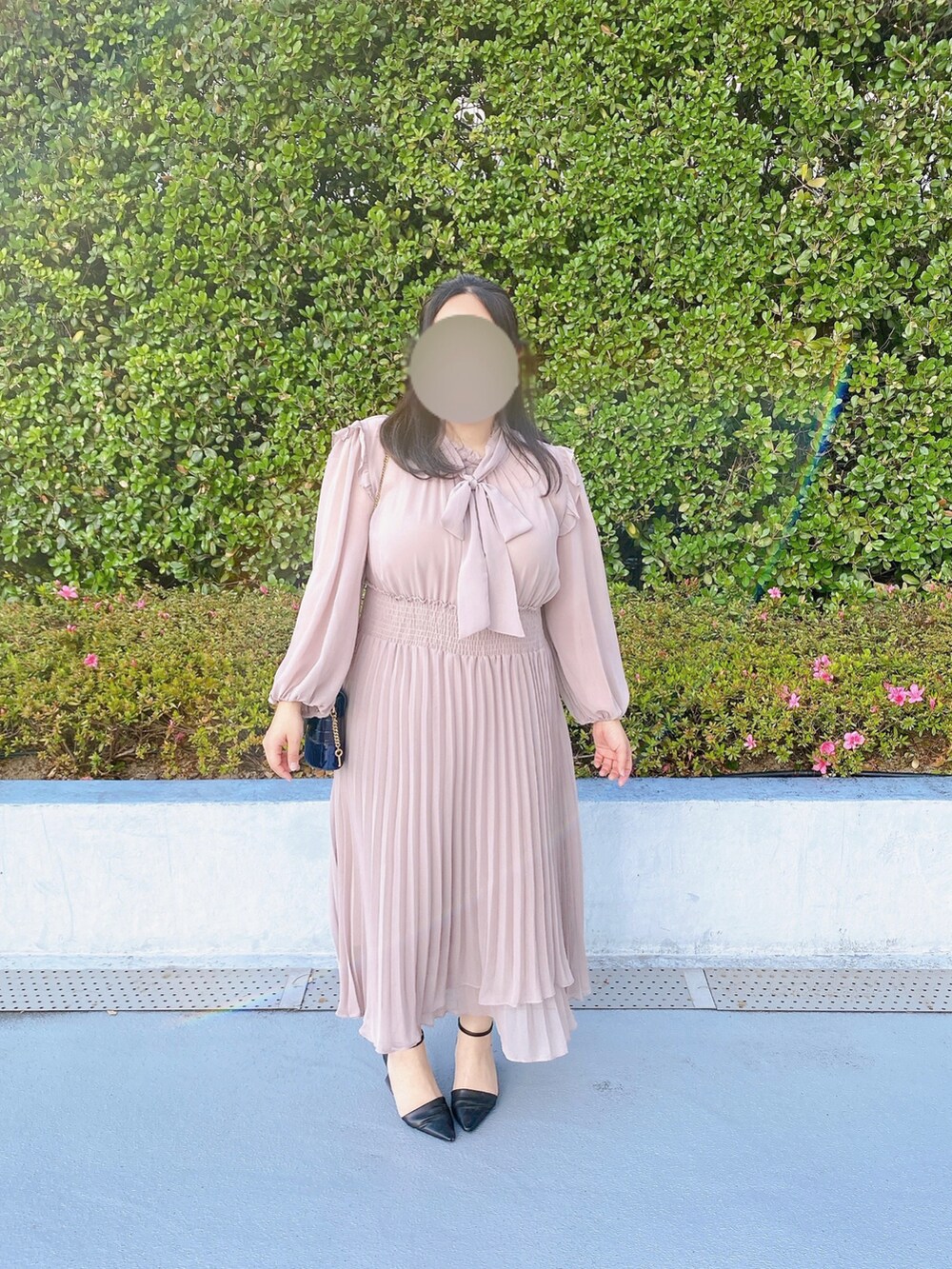ブルー系のショルダーバッグ、ブラック系のパンプス、ピンク系のワンピースを着用したレディースの春コーディネートの2枚目の写真