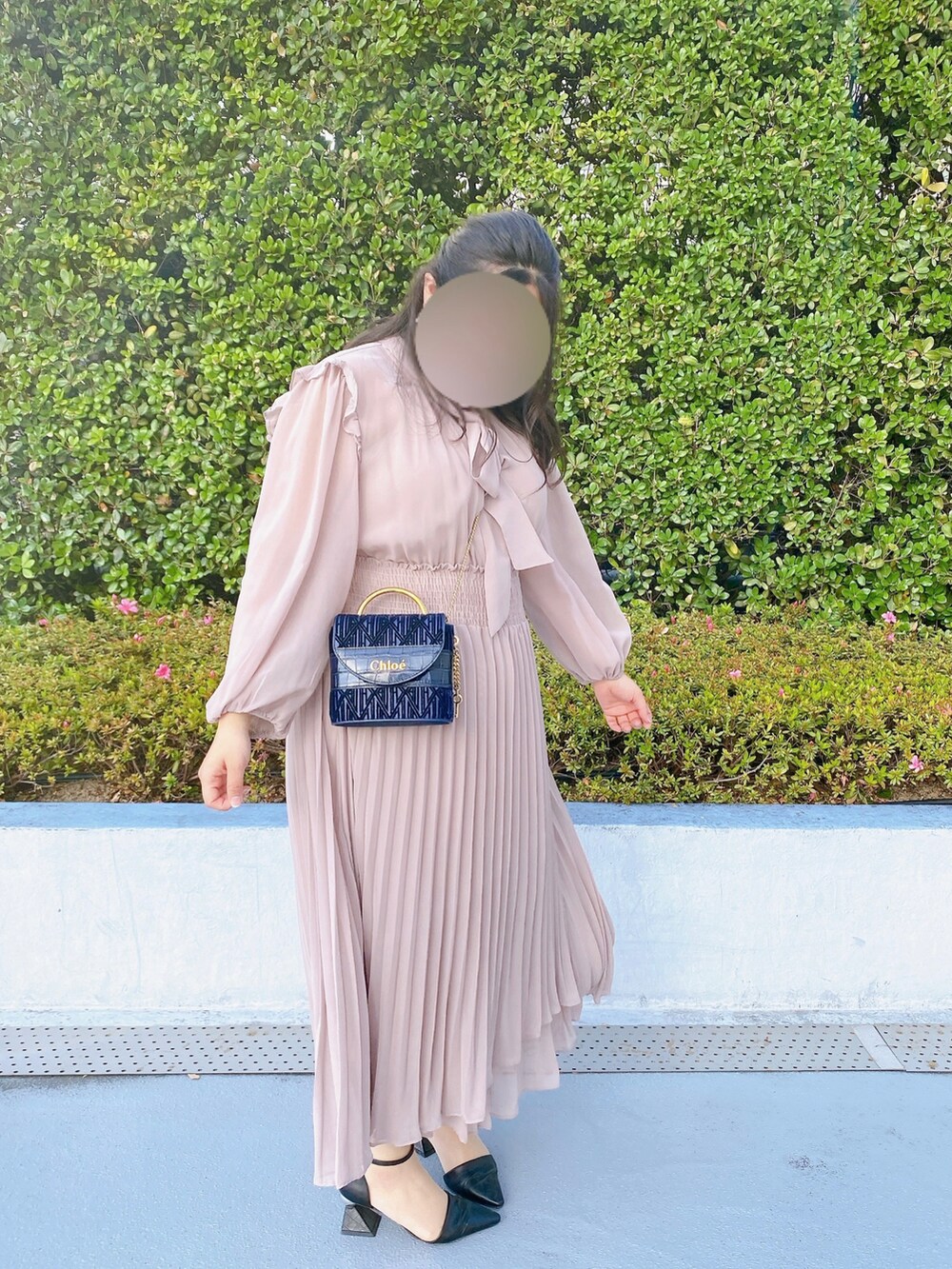 ブルー系のショルダーバッグ、ブラック系のパンプス、ピンク系のワンピースを着用したレディースの春コーディネートの3枚目の写真