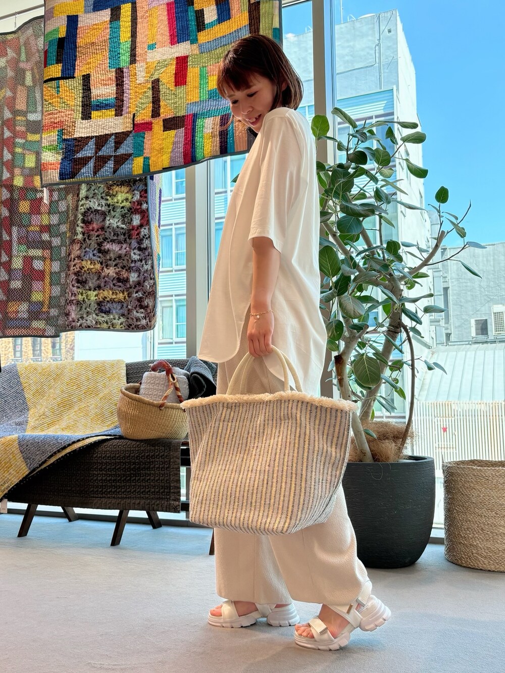 ホワイト系のTシャツ/カットソー、ホワイト系のかごバッグ、ゴールド系のネックレスを着用したレディースの夏コーディネートの3枚目の写真