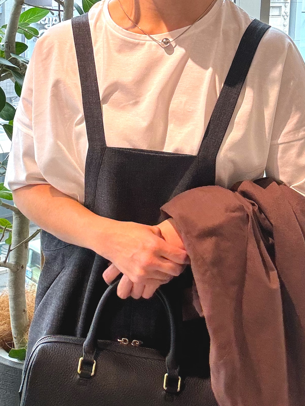 ブラウン系のテーラードジャケット、ブラック系のボストンバッグ、ブラック系のサロペット/オーバーオールを着用したレディースの春コーディネートの5枚目の写真