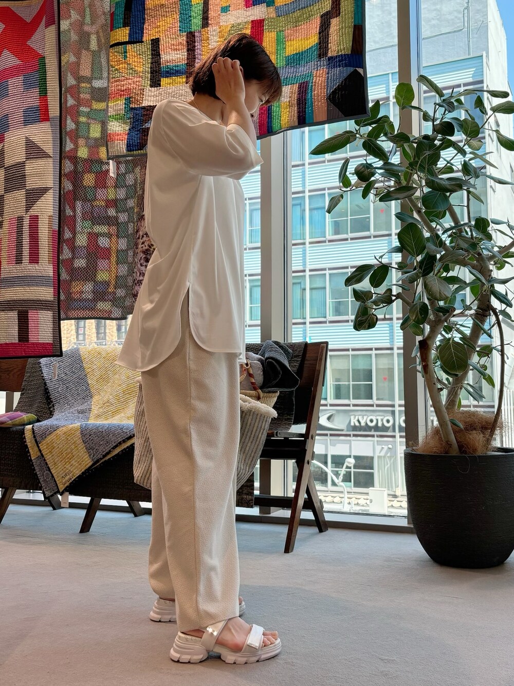 ホワイト系のTシャツ/カットソー、ホワイト系のかごバッグ、ゴールド系のネックレスを着用したレディースの夏コーディネートの4枚目の写真