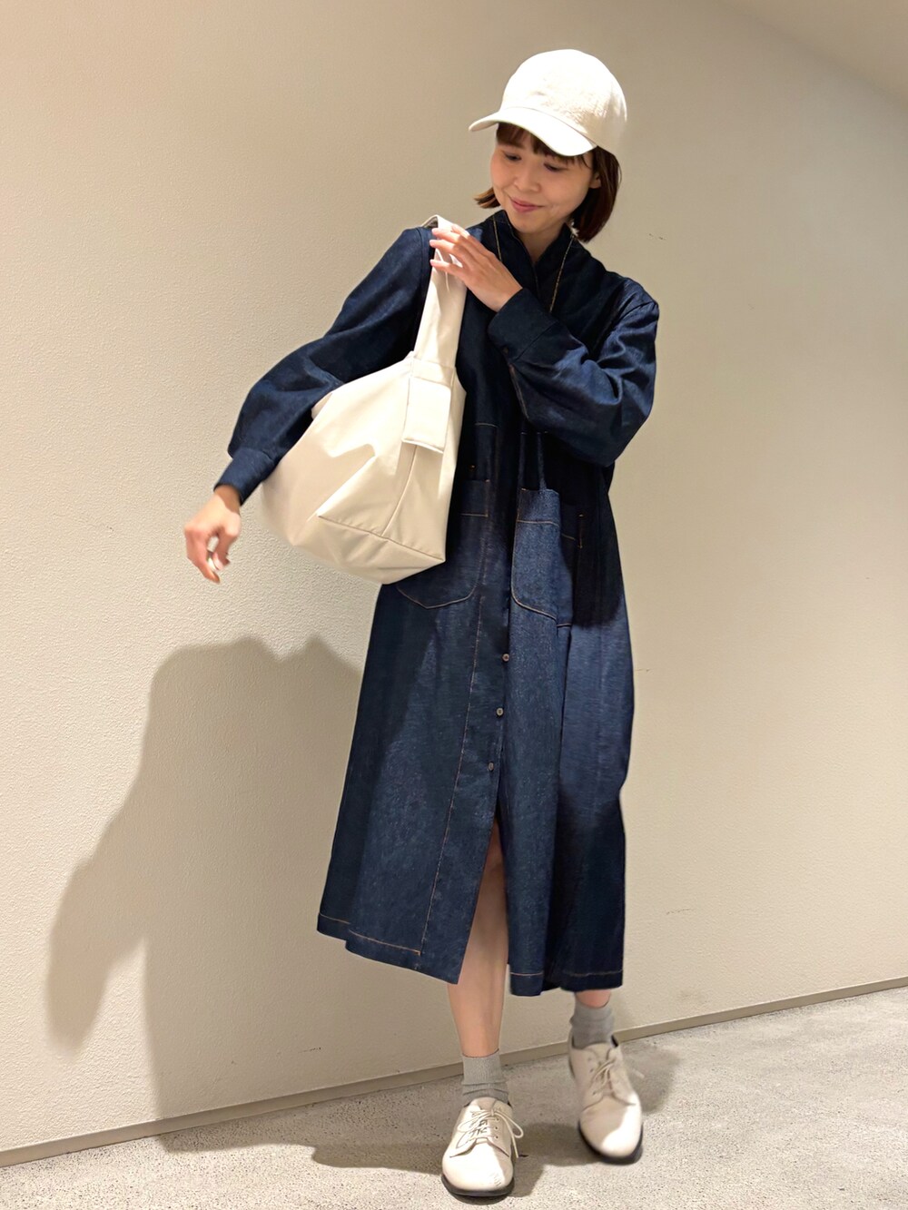 ブルー系のシャツワンピース、ゴールド系のネックレスを着用したレディースの春コーディネートの2枚目の写真