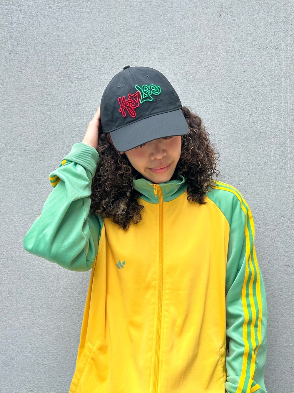 イエロー系のジャージ、ブルー系のデニムパンツ、イエロー系のブーツを着用したレディースの夏コーディネートの2枚目の写真