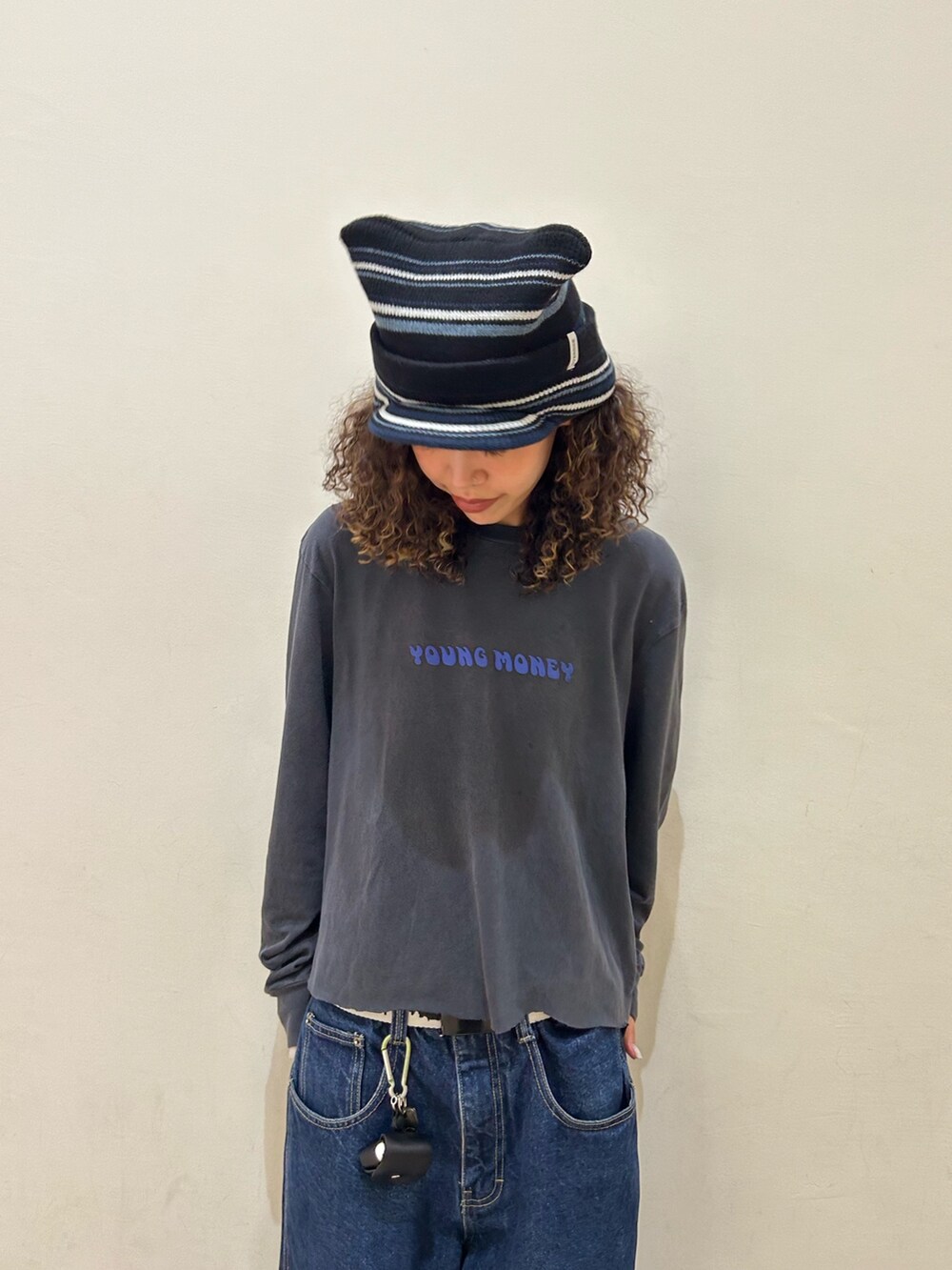 ブラック系のTシャツ/カットソー、ブルー系のデニムパンツ、ブラック系のスニーカーを着用したレディースの夏コーディネートの3枚目の写真