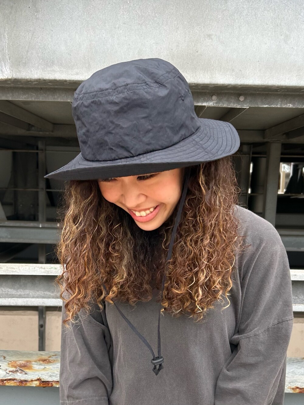 グレー系のTシャツ/カットソー、グレー系のサンダル、ブルー系のデニムパンツを着用したレディースの夏コーディネートの2枚目の写真