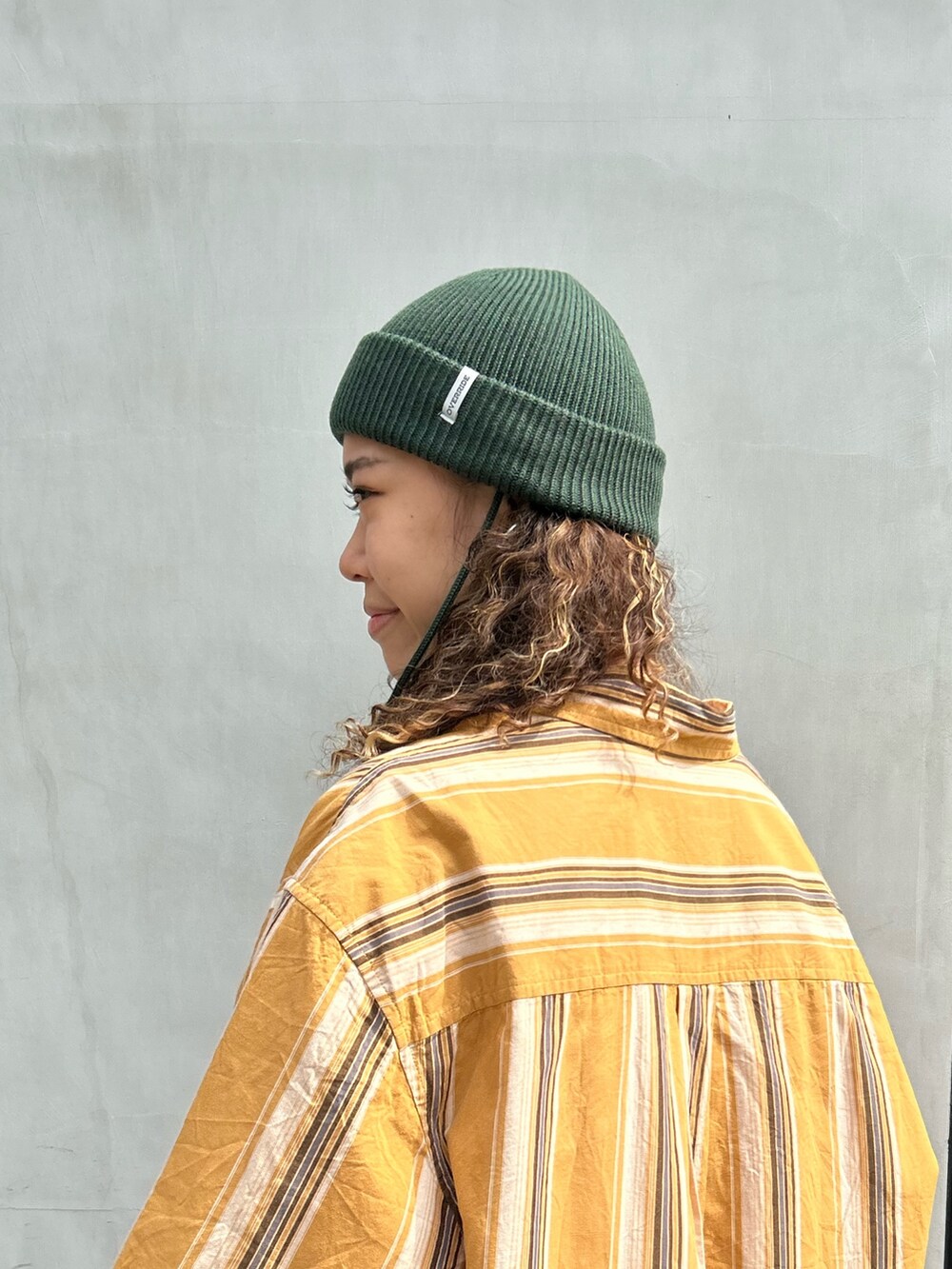 イエロー系のシャツ/ブラウス、ブルー系のデニムパンツ、ブラック系のスニーカーを着用したレディースの秋コーディネートの2枚目の写真
