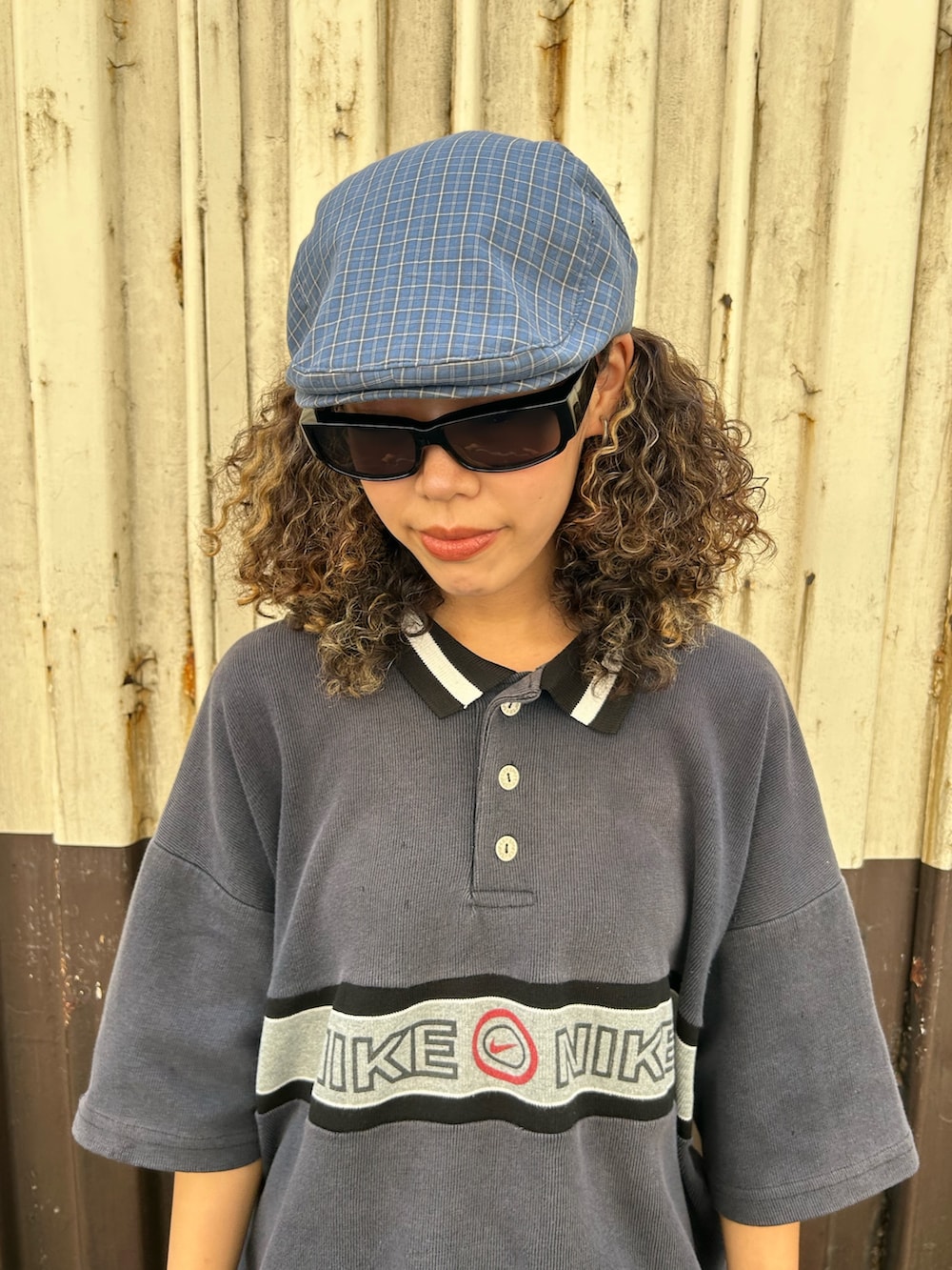 グレー系のトップス、ブルー系のデニムパンツ、イエロー系のブーツを着用したレディースの夏コーディネートの2枚目の写真