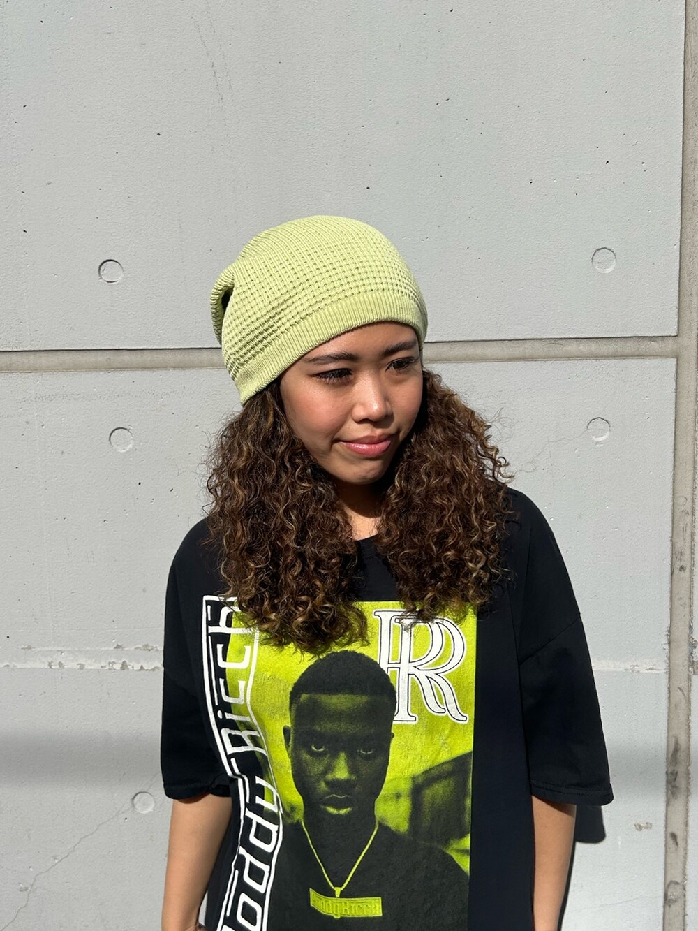 ブラック系のTシャツ/カットソー、グリーン系のカーゴパンツ、ブラック系のスニーカーを着用したレディースの春コーディネートの2枚目の写真