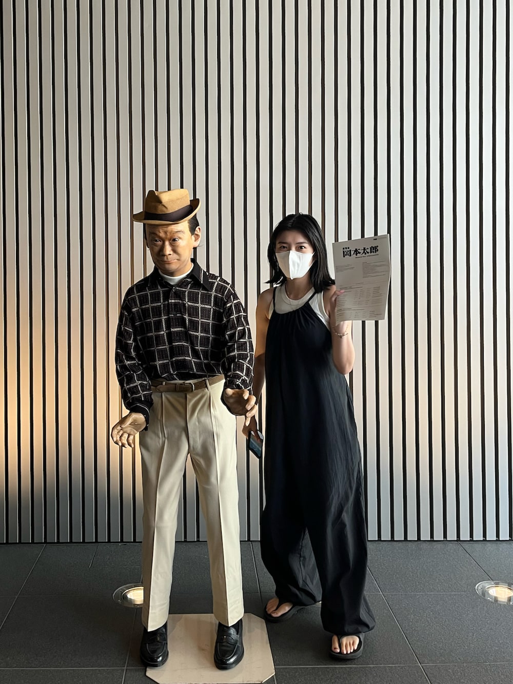 ブラック系のオールインワン・サロペット、ブラック系のサンダルを着用したレディースの夏コーディネートの2枚目の写真