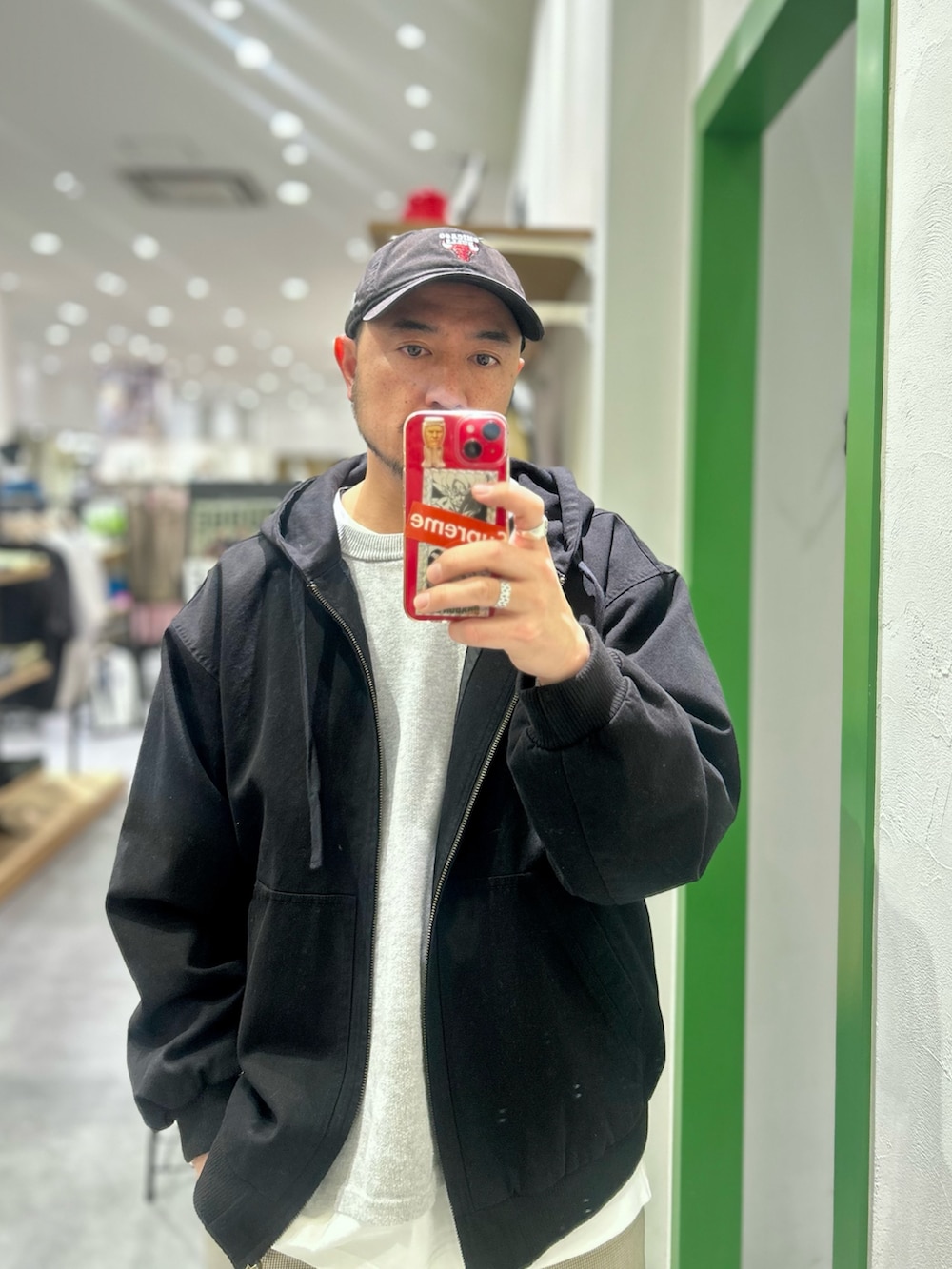 レッド系のニット/セーター、ブラック系のデニムジャケット、ベージュ系のその他パンツを着用したメンズの冬コーディネートの2枚目の写真