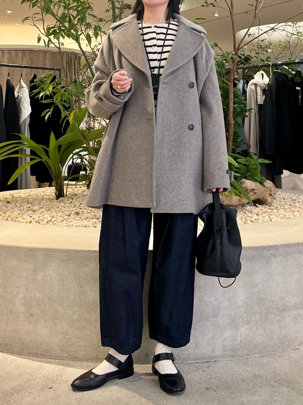 グレー系のピーコート、その他のカーディガン/ボレロ、ブルー系のデニムパンツを着用したレディースの冬コーディネートの6枚目の写真