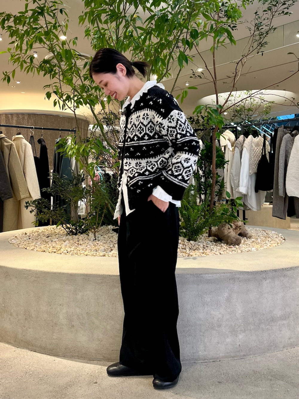 ブラック系のカーディガン/ボレロ、ブラック系のその他パンツ、ホワイト系のシャツ/ブラウスを着用したレディースの秋コーディネートの2枚目の写真