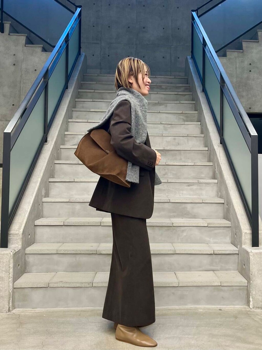 ブラウン系のその他アウター、ブラウン系のスカート、ブラウン系のニット/セーターを着用したレディースの秋コーディネートの2枚目の写真