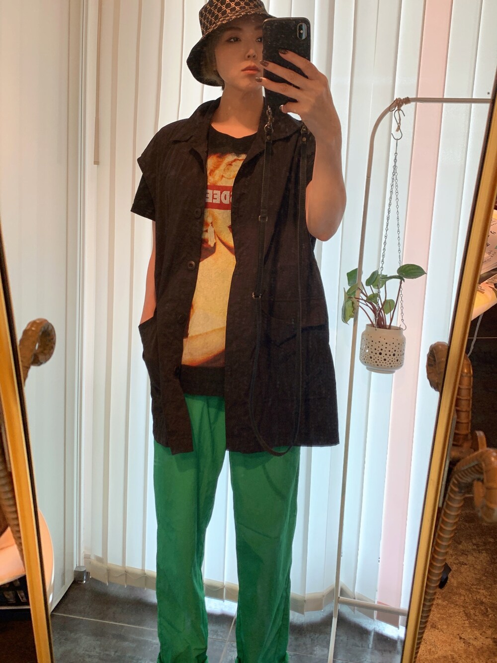 ブラック系のTシャツ/カットソー、ブラック系のベスト、グリーン系のパンツを着用したレディースの秋コーディネートの2枚目の写真