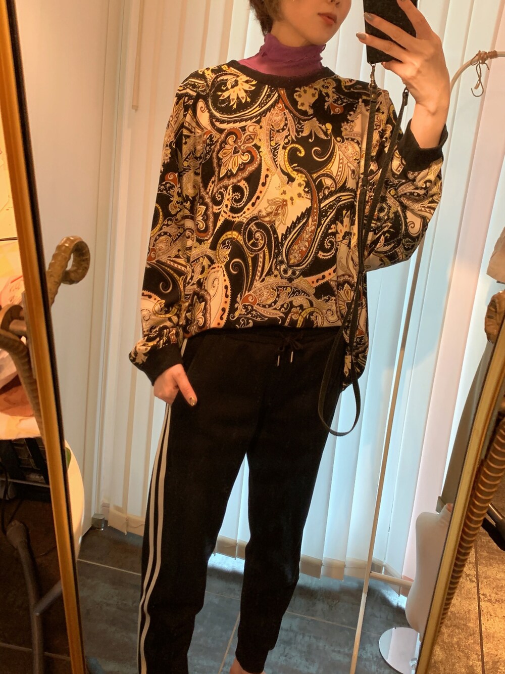 ブラック系のスウェットパンツ、ブラック系のスウェット、パープル系のTシャツ/カットソーを着用したレディースの秋コーディネートの2枚目の写真