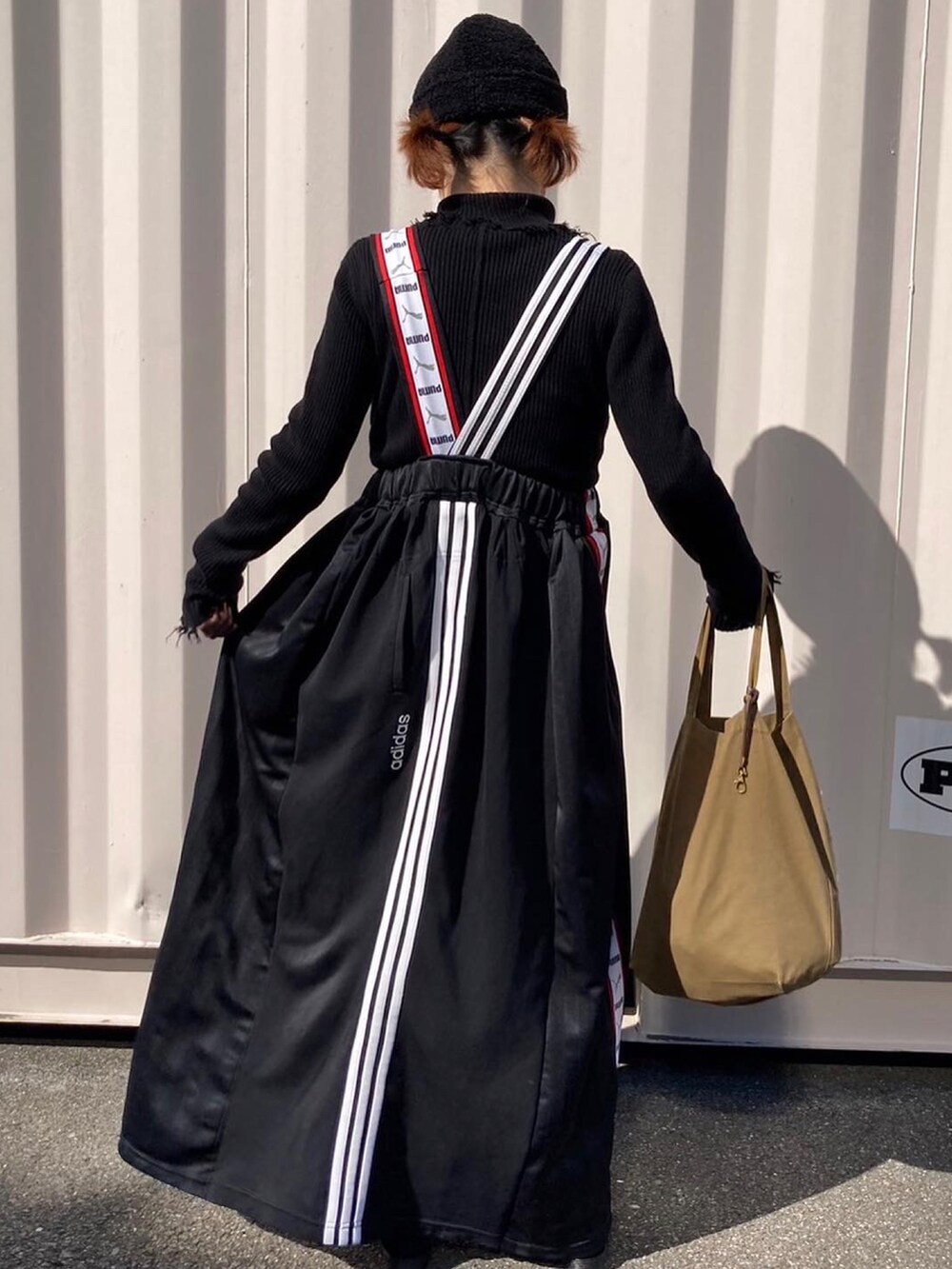 ブラック系のニット/セーター、ブラック系のスカート、ブラック系のサンダルを着用したレディースの秋コーディネートの2枚目の写真