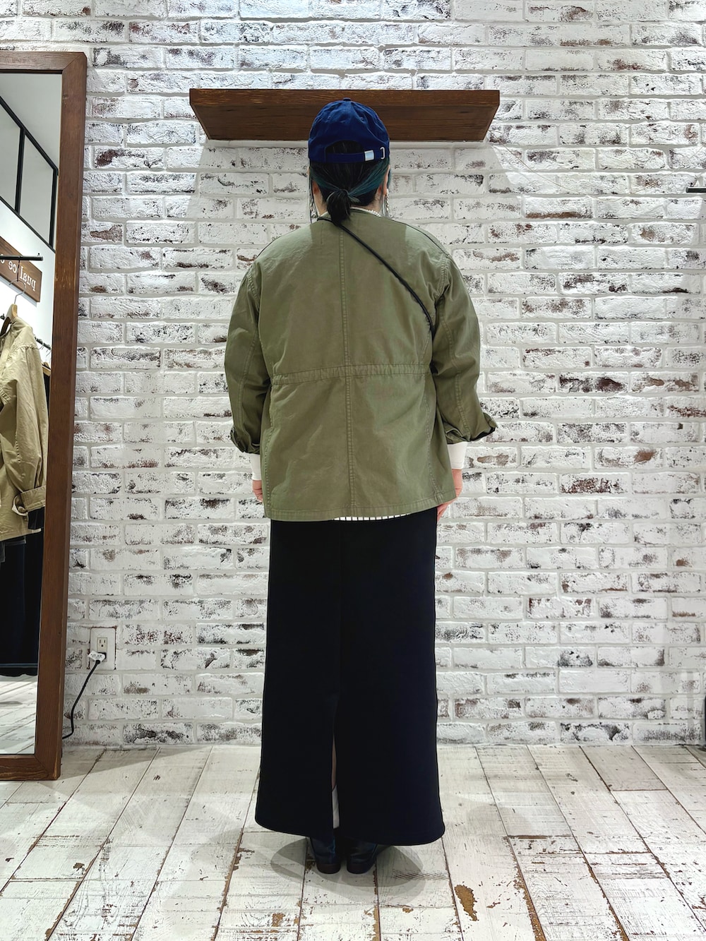 グリーン系のミリタリージャケット、その他のTシャツ/カットソー、ブラック系のスカートを着用したレディースの春コーディネートの5枚目の写真