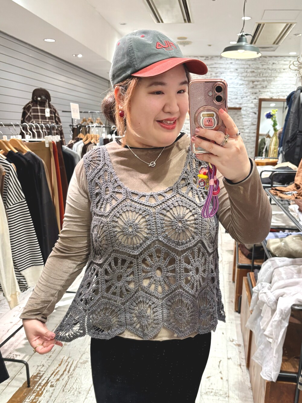 レッド系のスニーカー、グレー系のベスト、ブラック系のスカートを着用したレディースの秋コーディネートの5枚目の写真