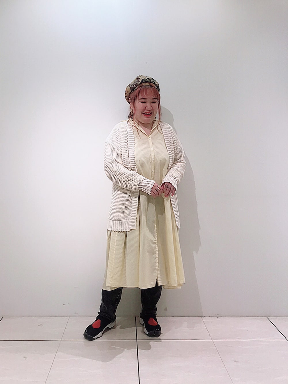 イエロー系のシャツワンピース、ホワイト系のカーディガン/ボレロ、グレー系のデニムパンツを着用したレディースの春コーディネートの3枚目の写真