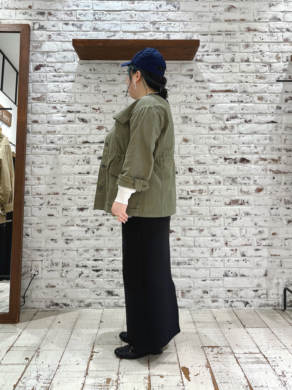 グリーン系のミリタリージャケット、その他のTシャツ/カットソー、ブラック系のスカートを着用したレディースの春コーディネートの4枚目の写真