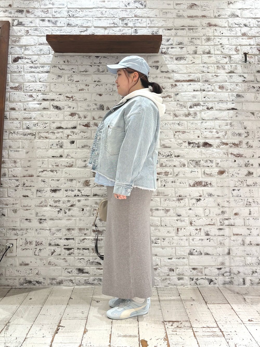 ホワイト系のパーカー、ブルー系のシャツ/ブラウス、グレー系のスカートを着用したレディースの冬コーディネートの3枚目の写真