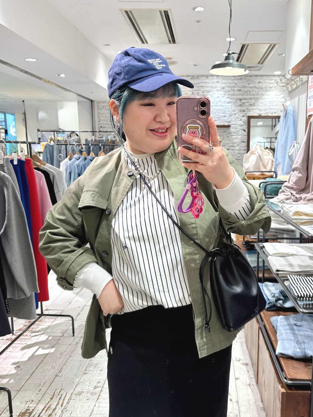 グリーン系のミリタリージャケット、その他のTシャツ/カットソー、ブラック系のスカートを着用したレディースの春コーディネートの3枚目の写真