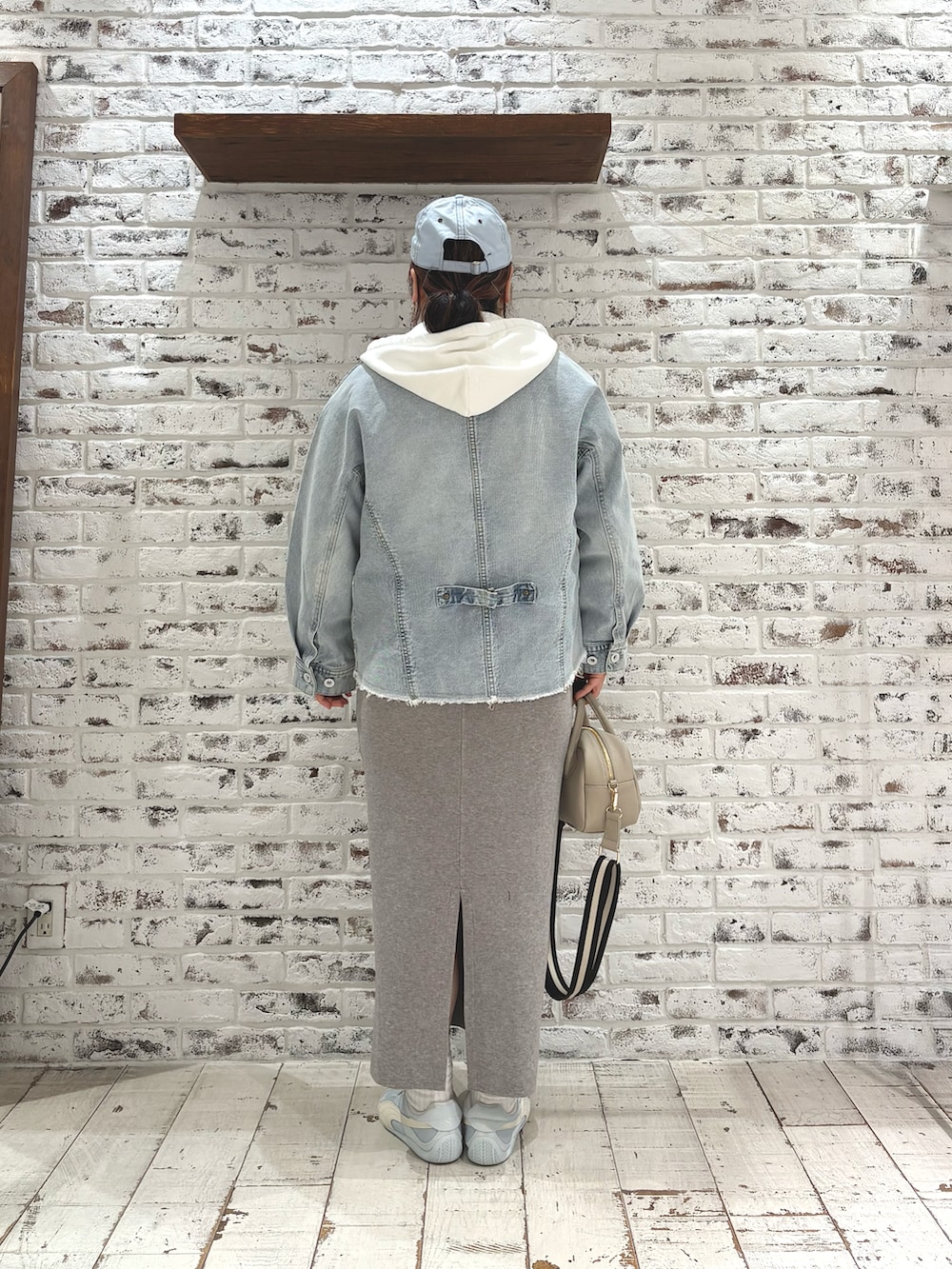 ホワイト系のパーカー、ブルー系のシャツ/ブラウス、グレー系のスカートを着用したレディースの冬コーディネートの4枚目の写真