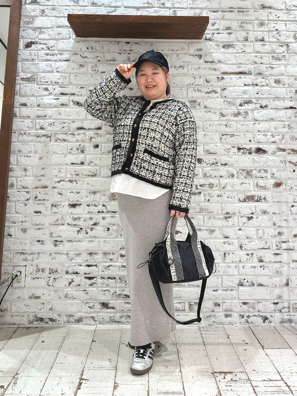 ブラック系のカーディガン/ボレロ、ホワイト系のシャツ/ブラウス、グレー系のスカートを着用したレディースの冬コーディネートの2枚目の写真