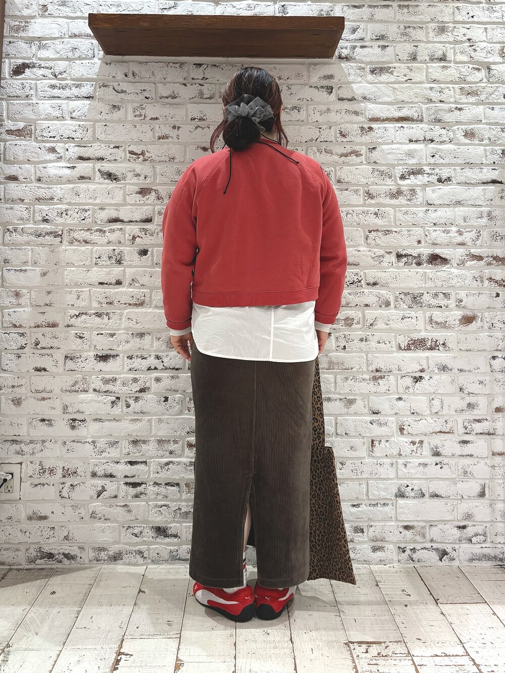 レッド系のスウェット、グリーン系のスカート、ホワイト系のシャツ/ブラウスを着用したレディースの冬コーディネートの4枚目の写真