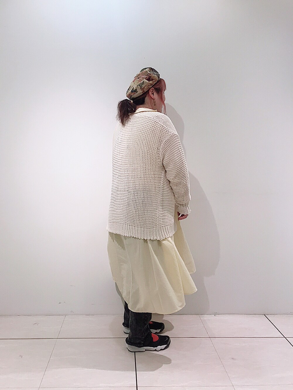 イエロー系のシャツワンピース、ホワイト系のカーディガン/ボレロ、グレー系のデニムパンツを着用したレディースの春コーディネートの5枚目の写真