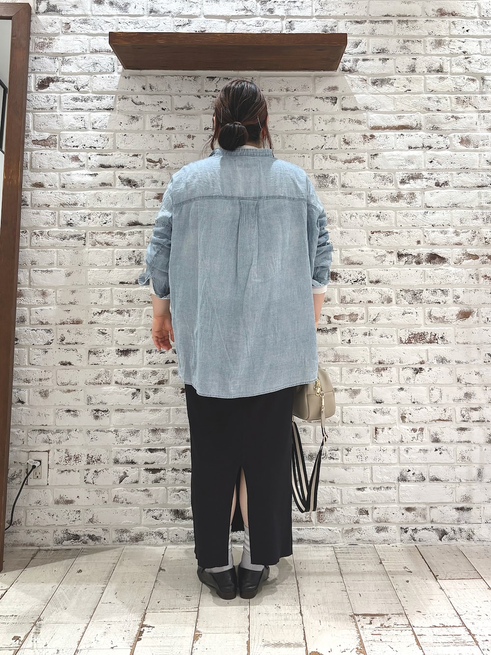 ブルー系のシャツ/ブラウス、ベージュ系のトートバッグ、ホワイト系のTシャツ/カットソーを着用したレディースの春コーディネートの4枚目の写真