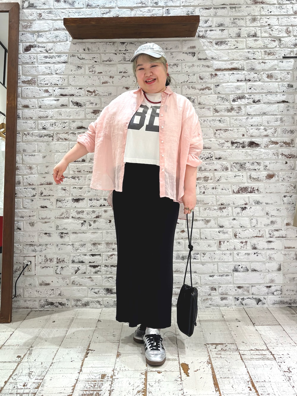 ピンク系のシャツ/ブラウス、ホワイト系のTシャツ/カットソー、ブラック系のスカートを着用したレディースの夏コーディネートの2枚目の写真