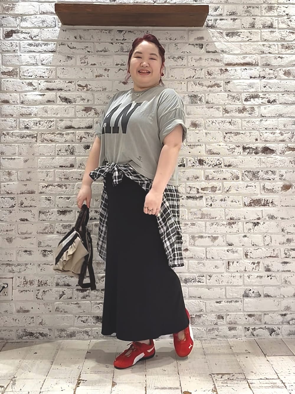 ベージュ系のショルダーバッグ、レッド系のスニーカー、グレー系のTシャツ/カットソーを着用したレディースの夏コーディネートの2枚目の写真