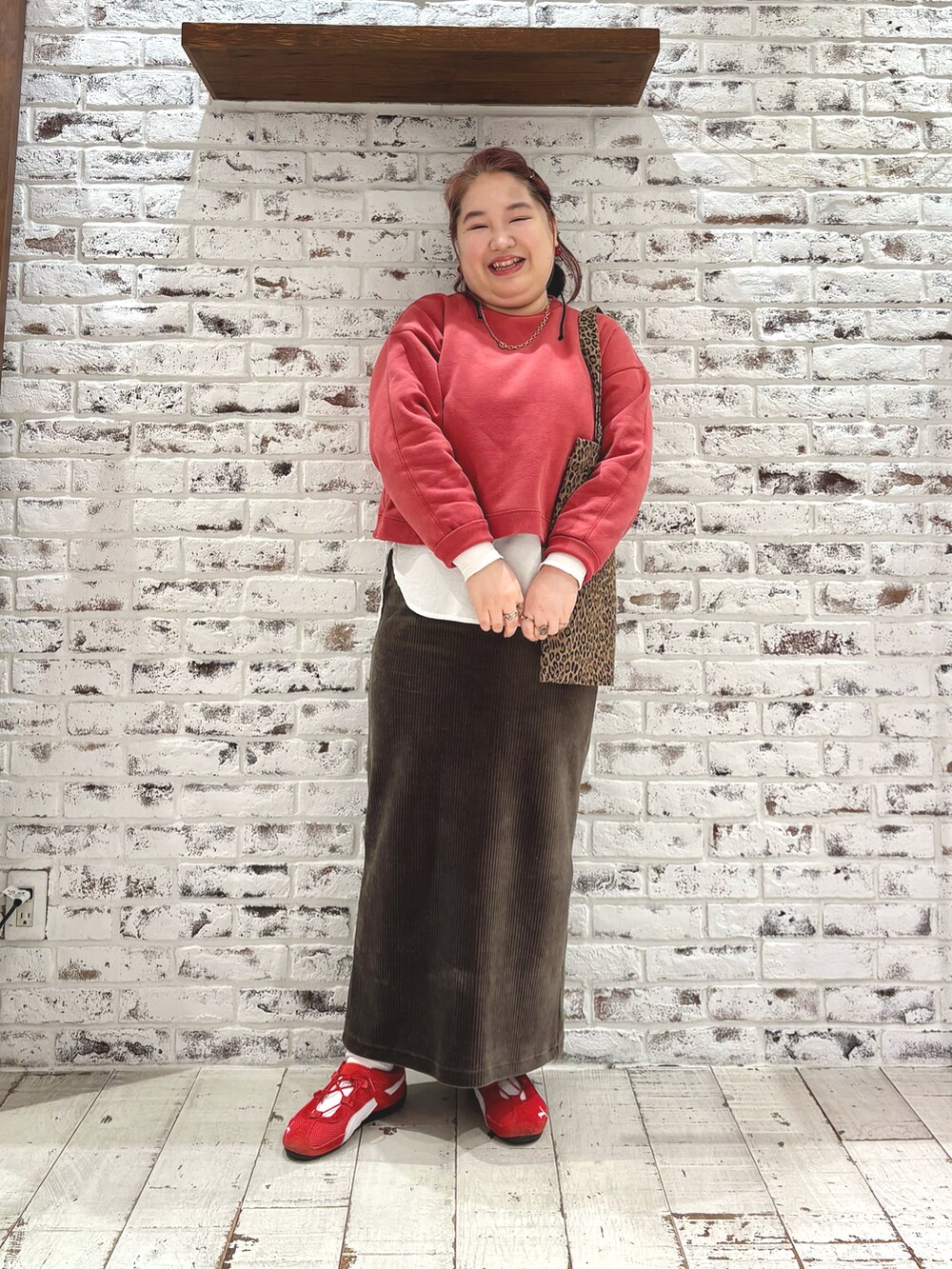 レッド系のスウェット、グリーン系のスカート、ホワイト系のシャツ/ブラウスを着用したレディースの冬コーディネートの2枚目の写真