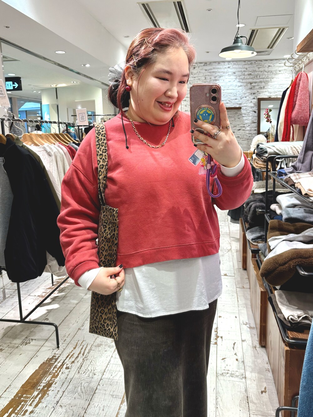 レッド系のスウェット、グリーン系のスカート、ホワイト系のシャツ/ブラウスを着用したレディースの冬コーディネートの5枚目の写真