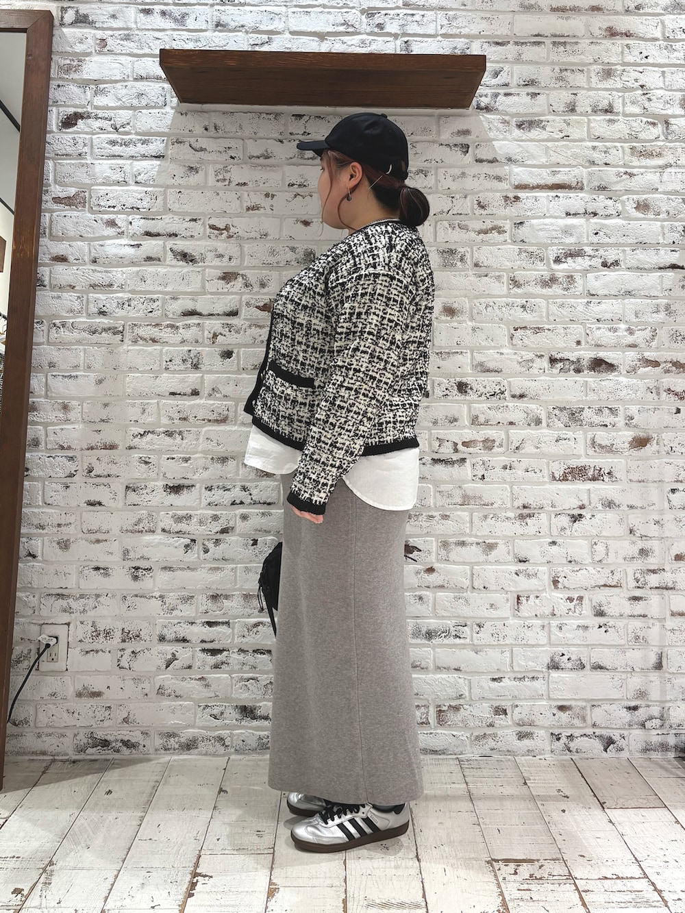 ブラック系のカーディガン/ボレロ、ホワイト系のシャツ/ブラウス、グレー系のスカートを着用したレディースの冬コーディネートの3枚目の写真