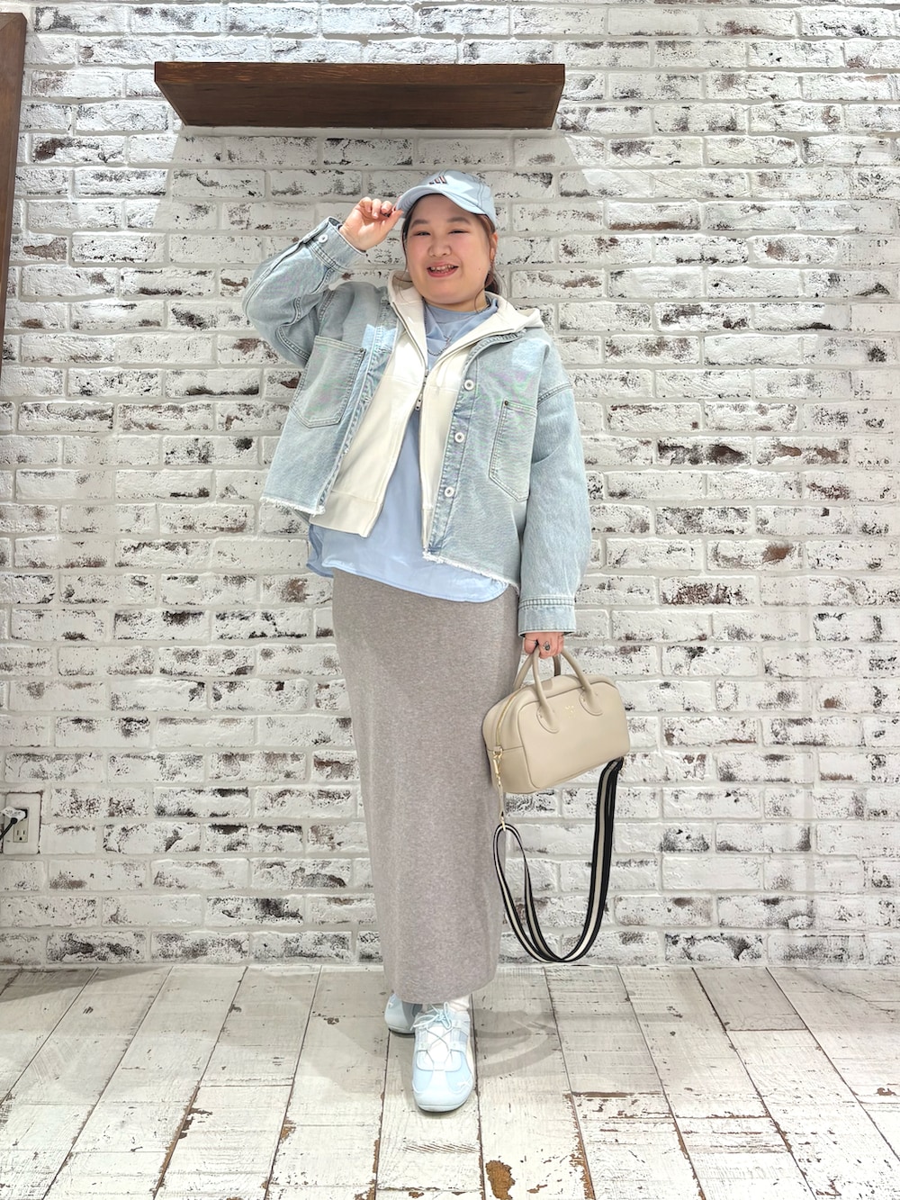 ホワイト系のパーカー、ブルー系のシャツ/ブラウス、グレー系のスカートを着用したレディースの冬コーディネートの2枚目の写真