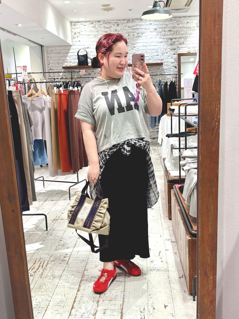 ベージュ系のショルダーバッグ、レッド系のスニーカー、グレー系のTシャツ/カットソーを着用したレディースの夏コーディネートの3枚目の写真