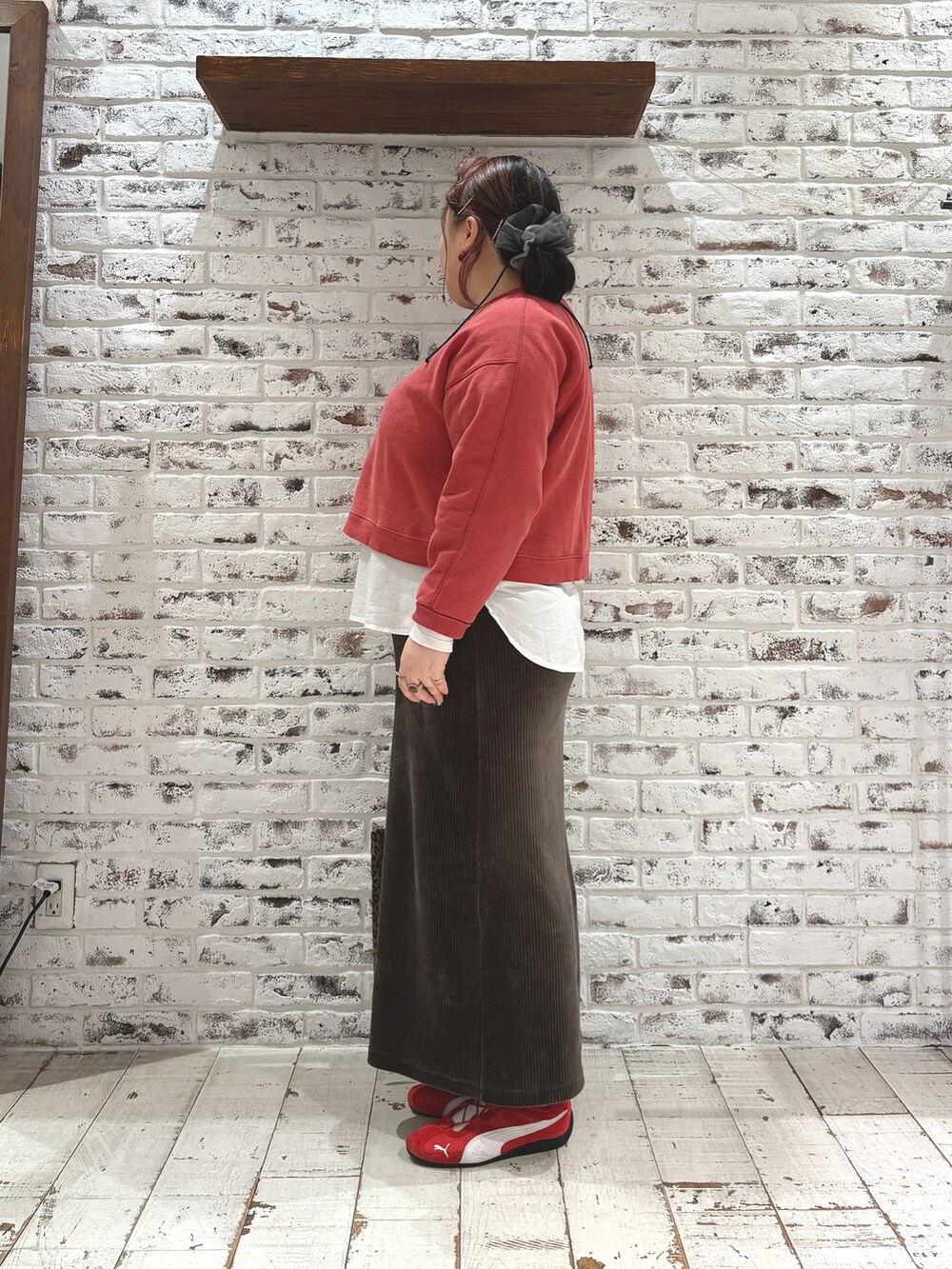 レッド系のスウェット、グリーン系のスカート、ホワイト系のシャツ/ブラウスを着用したレディースの冬コーディネートの3枚目の写真