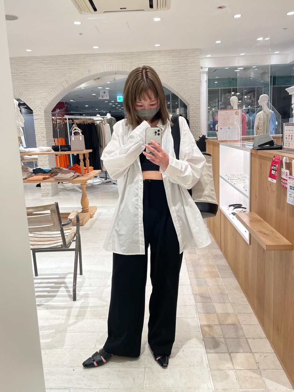 ブラック系のサンダル、ブラック系のショルダーバッグ、ホワイト系のシャツ/ブラウスを着用したレディースの春コーディネートの2枚目の写真