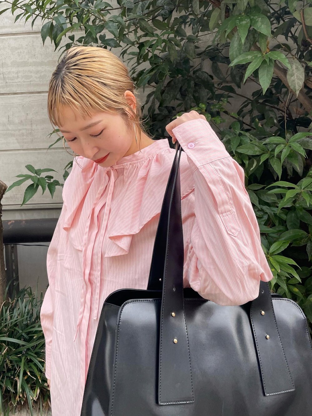 オレンジ系のシャツ/ブラウス、ブラウン系のトートバッグを着用したレディースの冬コーディネートの3枚目の写真