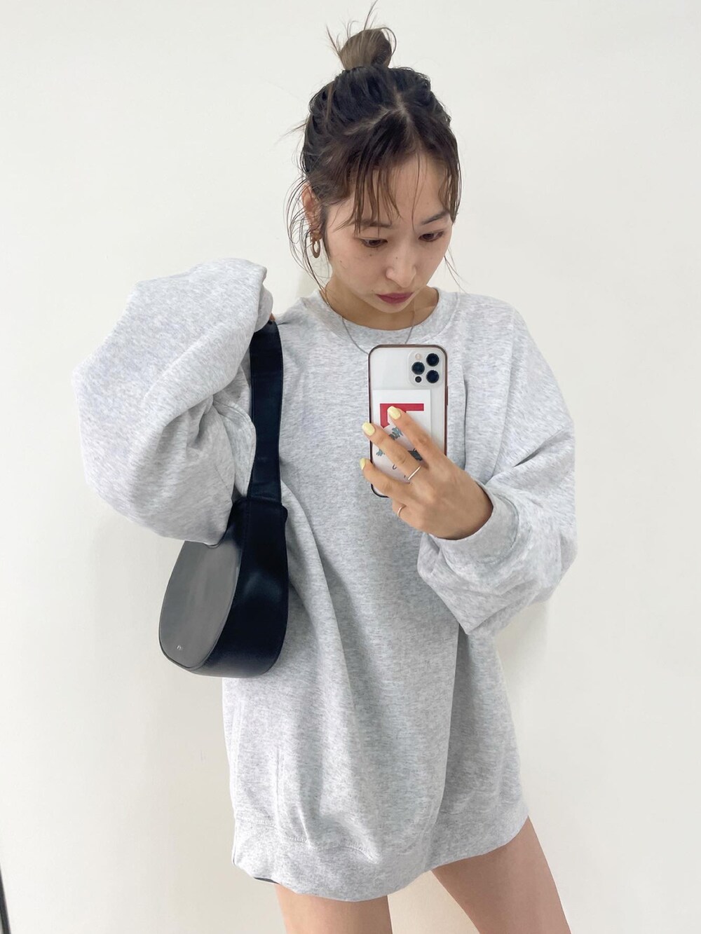 グレー系のスウェット、ブラック系のショルダーバッグを着用したレディースの秋コーディネートの2枚目の写真