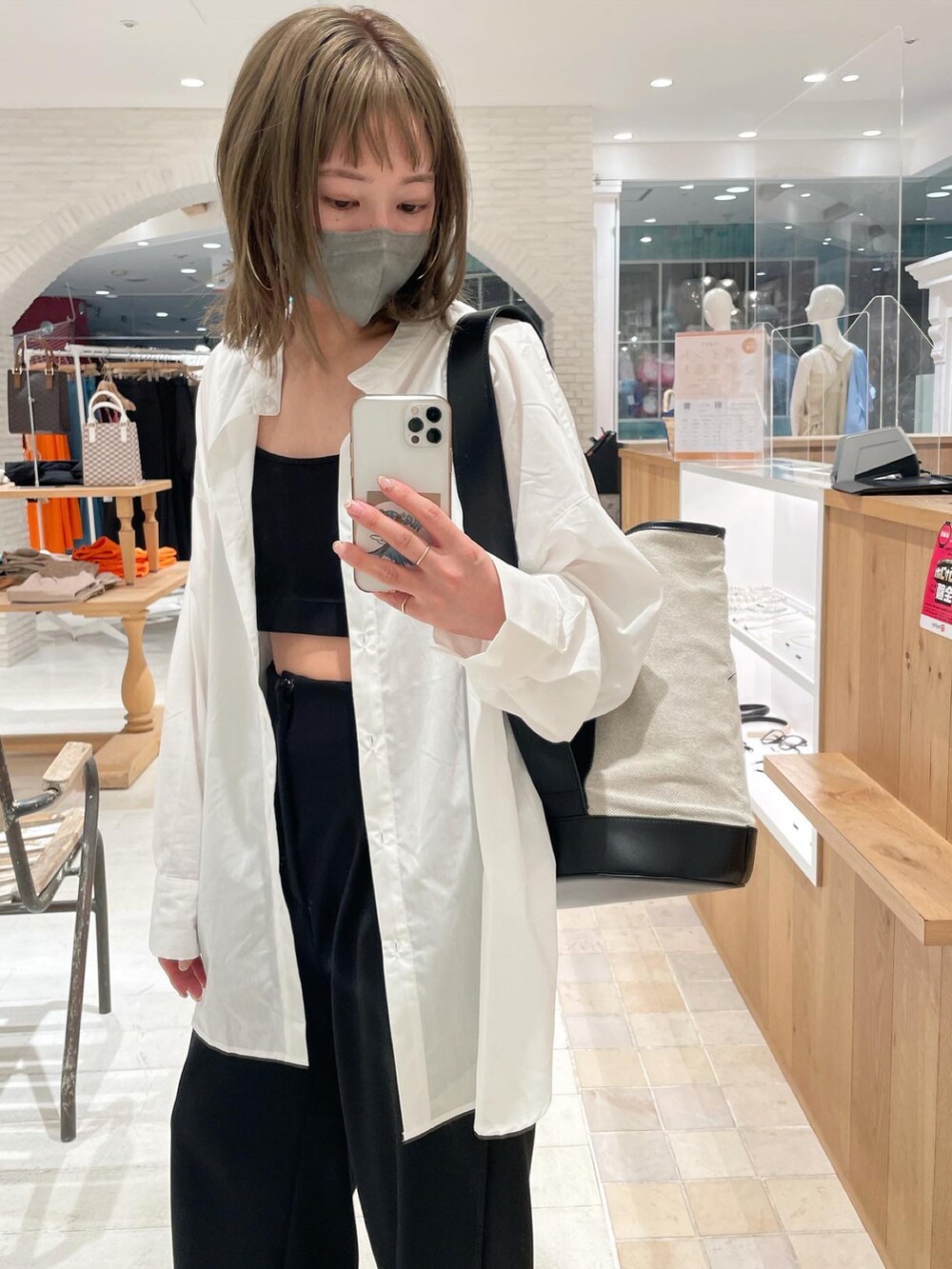 ブラック系のサンダル、ブラック系のショルダーバッグ、ホワイト系のシャツ/ブラウスを着用したレディースの春コーディネートの3枚目の写真