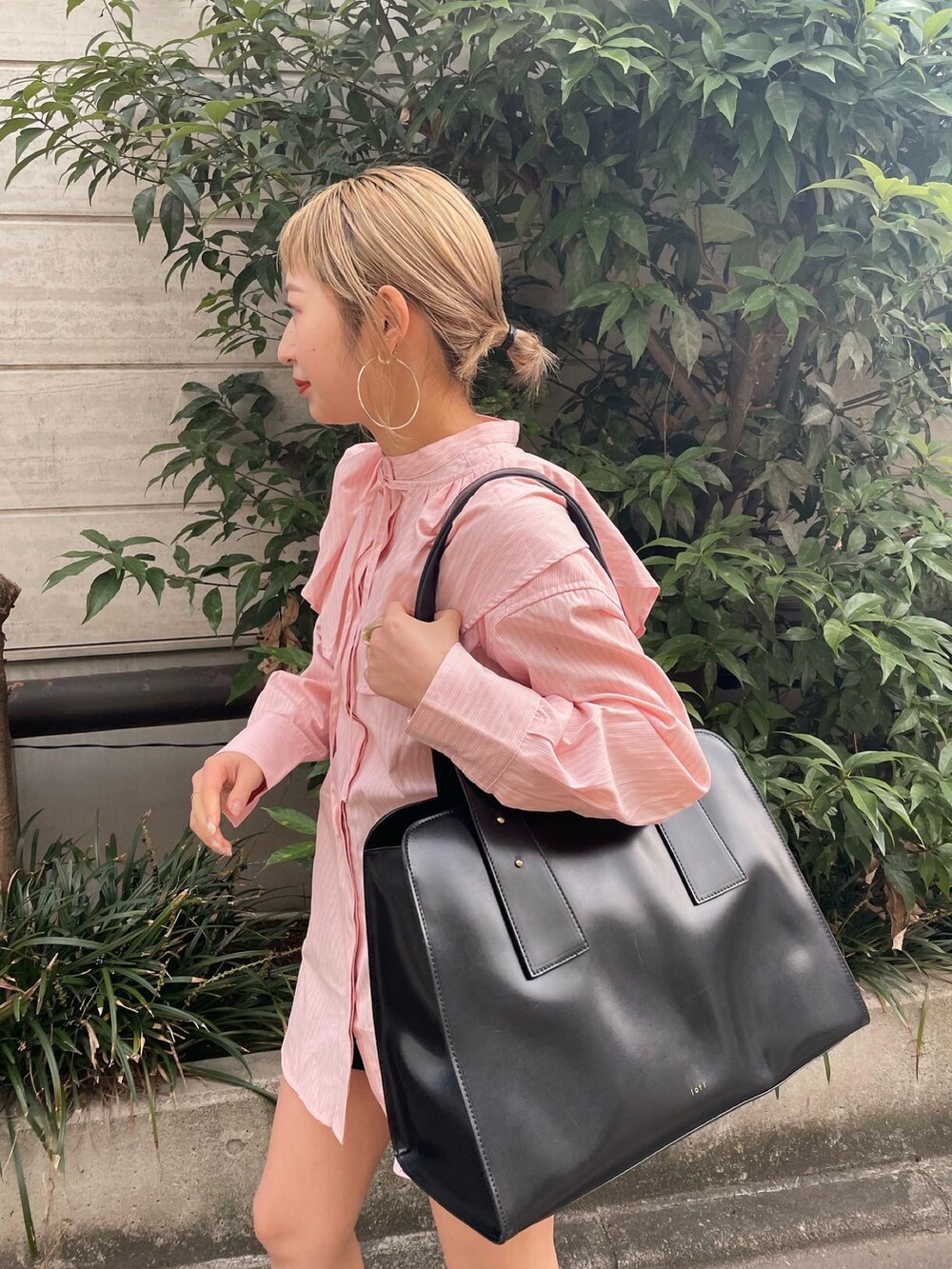 オレンジ系のシャツ/ブラウス、ブラウン系のトートバッグを着用したレディースの冬コーディネートの2枚目の写真