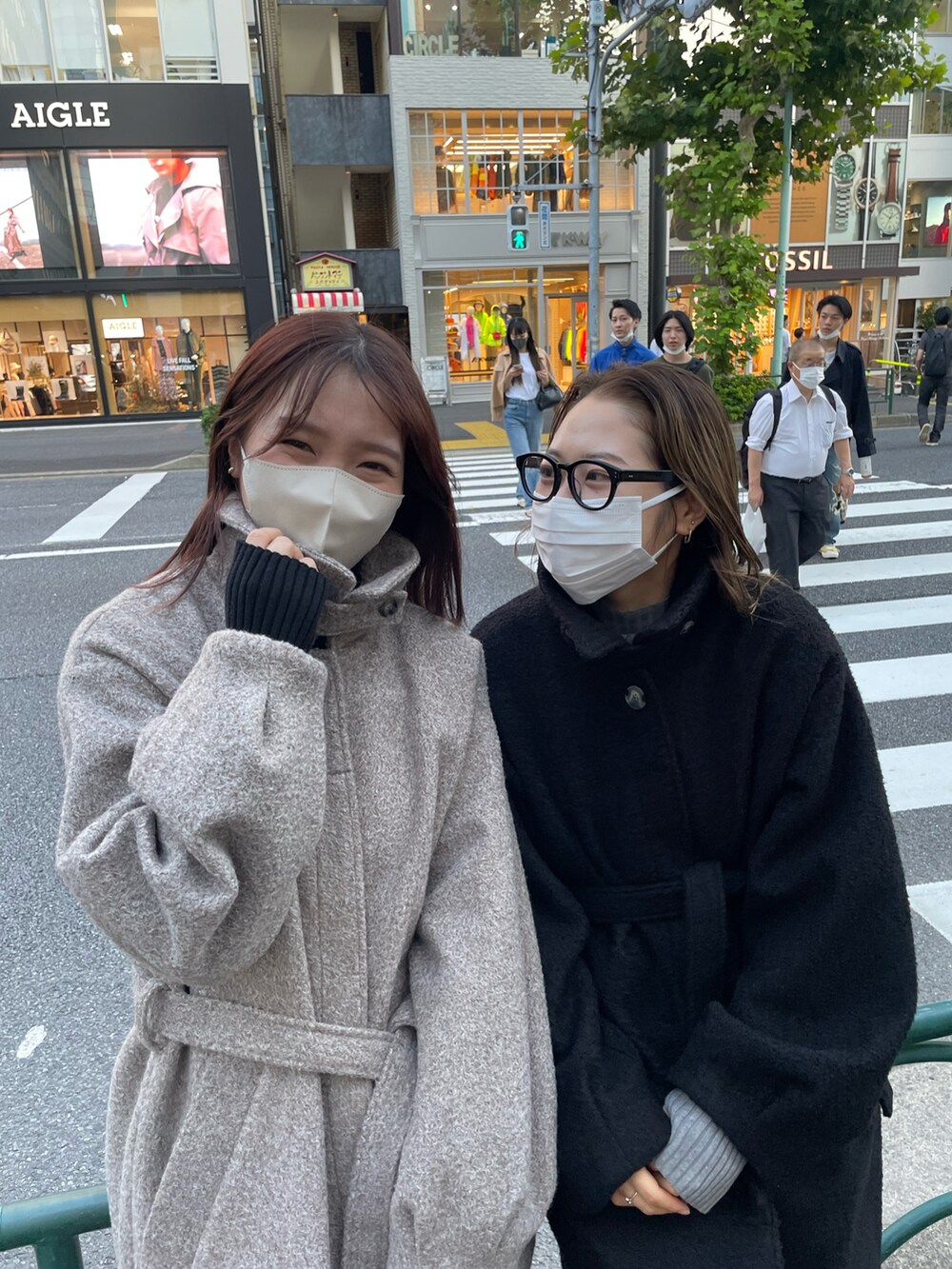 ブラック系のステンカラーコート、グレー系のニット/セーターを着用したレディースの秋コーディネートの2枚目の写真