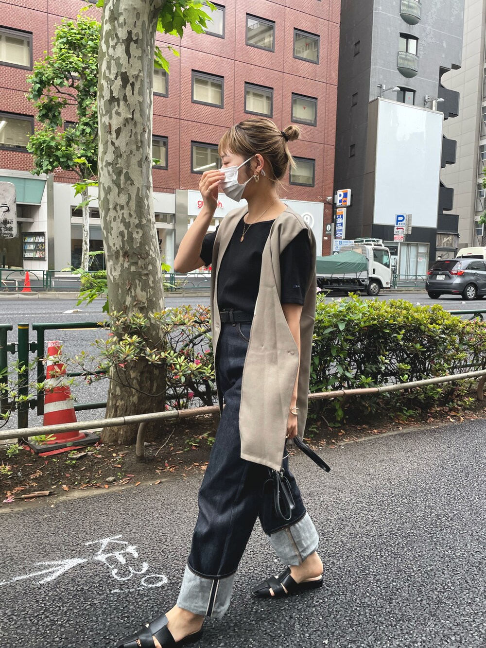 ブルー系のデニムパンツ、ブラック系のサンダル、ブラック系のTシャツ/カットソーを着用したレディースの春コーディネートの2枚目の写真