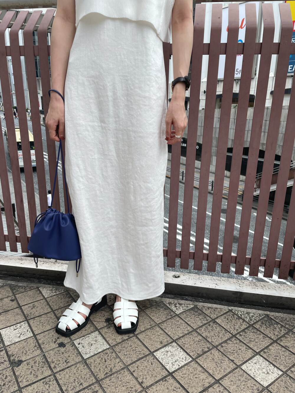 ホワイト系のワンピース、ブルー系のショルダーバッグ、ホワイト系のスリッポンを着用したレディースの夏コーディネートの3枚目の写真