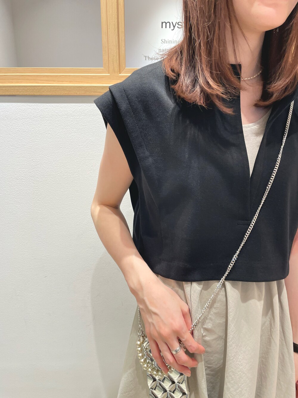ベージュ系のワンピース、ホワイト系のサンダル、シルバー系のスマホケース/カバーを着用したレディースの春コーディネートの2枚目の写真